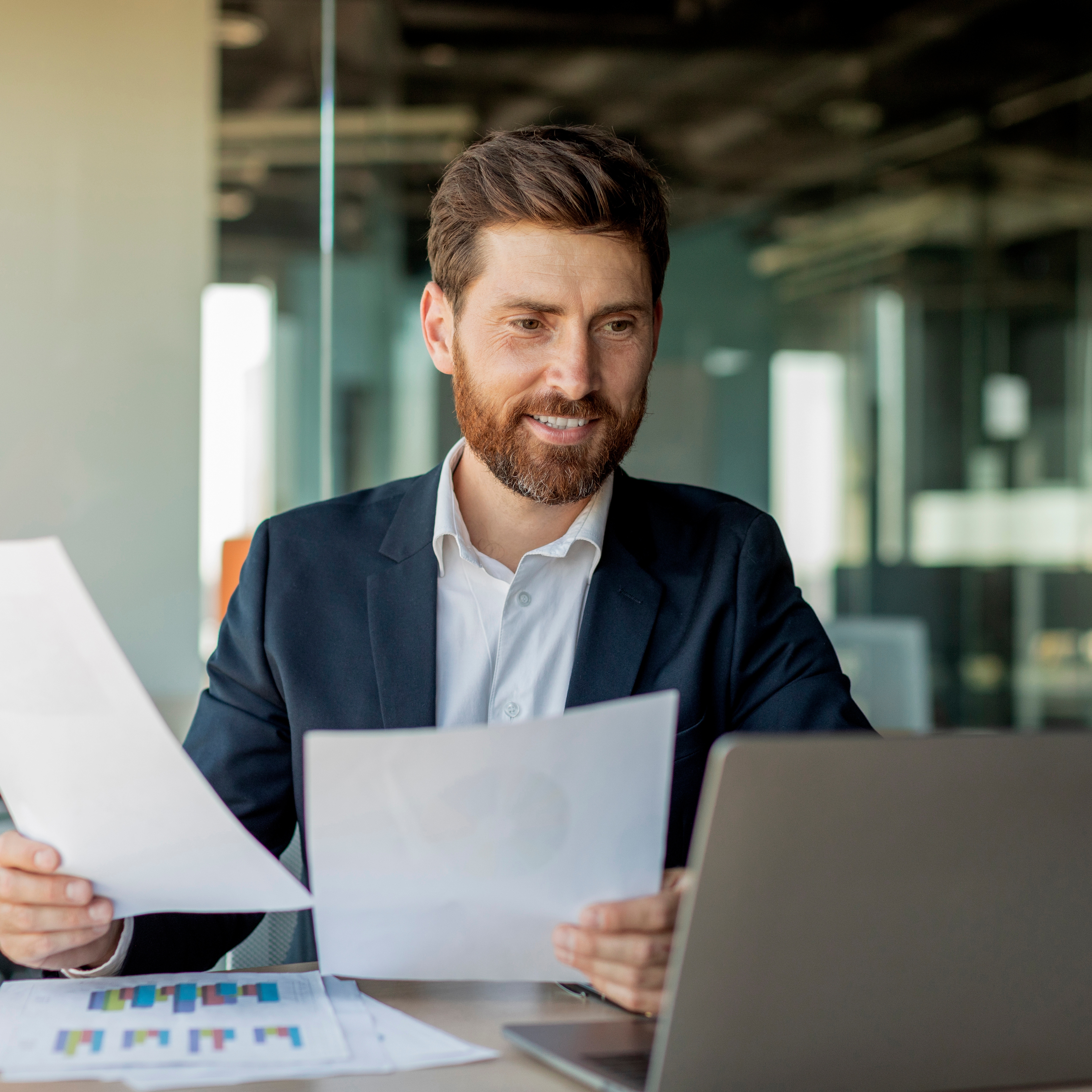 Businessman working with laptop and documents.