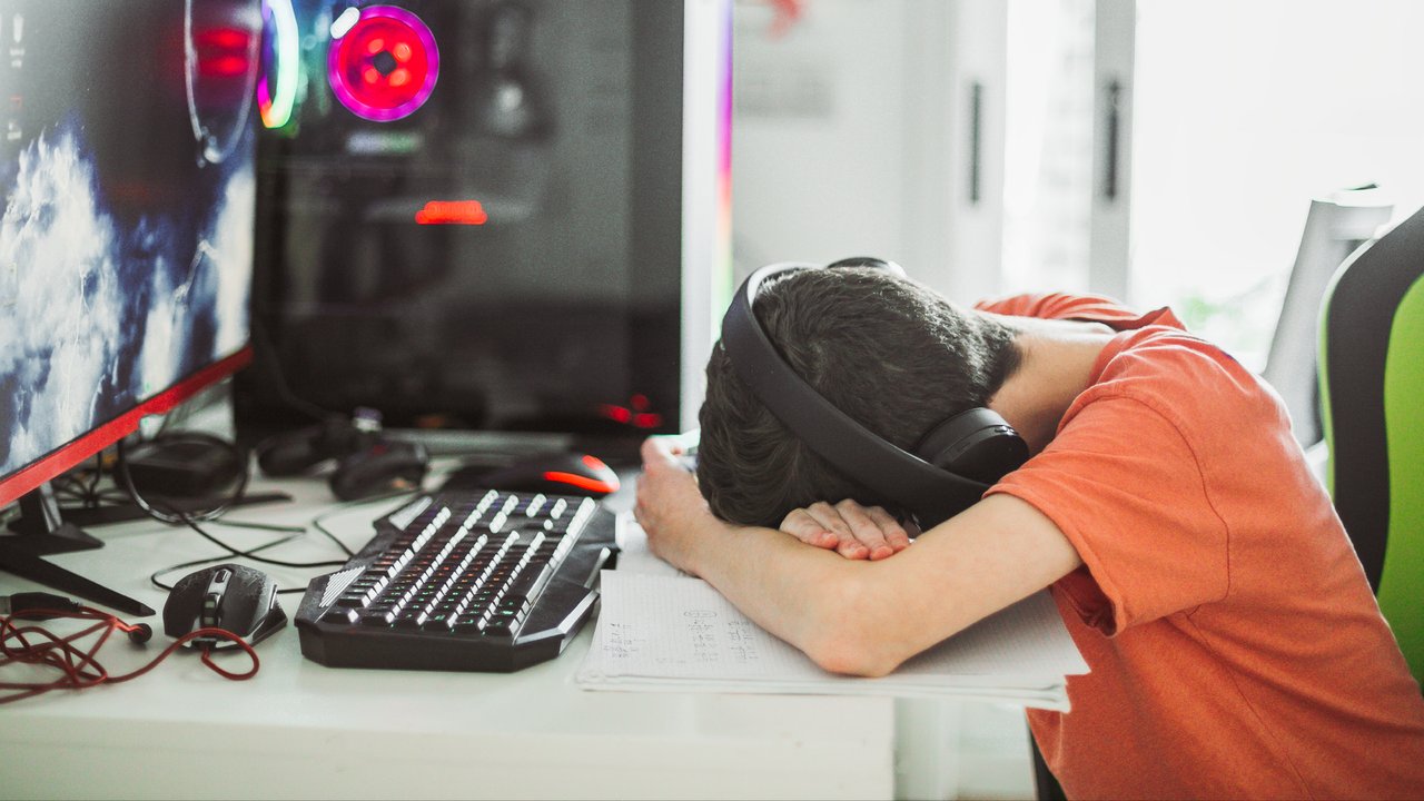 Examples of cyberbullying and insurance claims A cyberbullied student stressed and sitting at his desk with his head down in front of his computer