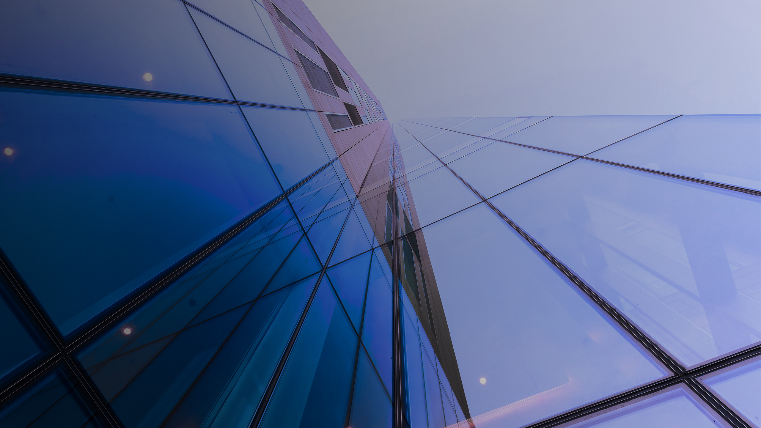 Financial institutions face new and emerging cyber risks A close-up view of a modern glass building, reflecting light and showing geometric patterns.